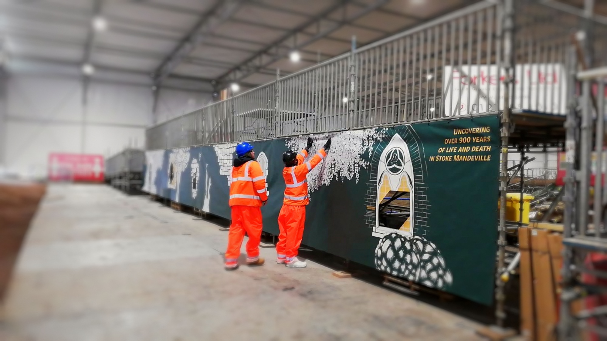 Site team putting up the hoarding graphics.